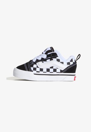 Sneaker a scacchi bianco e nero con tomaia in suede e tela, caratterizzata da lacci bianchi, colletto imbottito e dettaglio del logo rosso sul tallone.