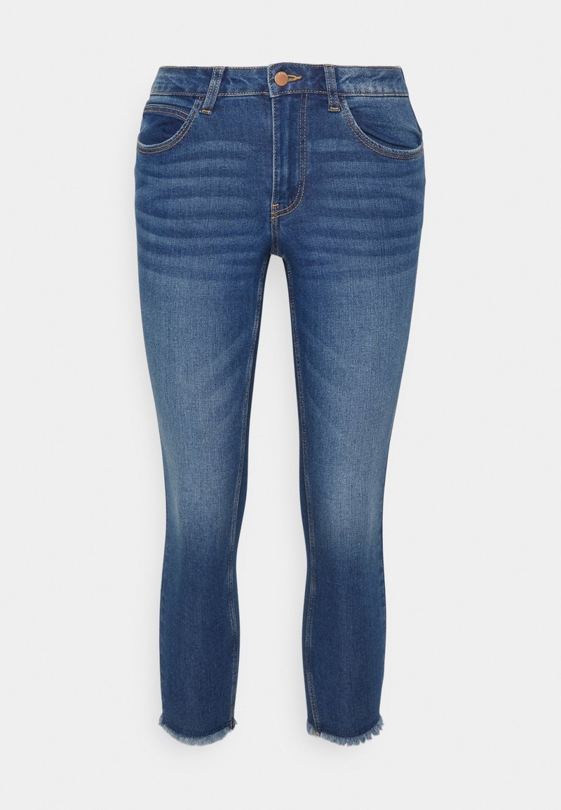 Jeans ajustados hechos de denim oscuro con un lavado ligeramente desgastado. Cuentan con cinco bolsillos, un cierre con botón y un dobladillo deshilachado en los tobillos.