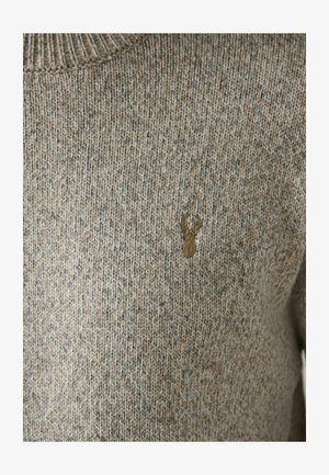 Beige-pruunis toonides kootud sviiter, millel on soonikservaga ümar kaelus. Rinnal on peene pruuni põdra embleem. Pehme tekstuur.