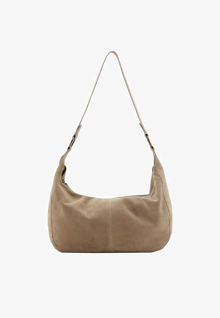 Sac à épaule en suède beige avec une forme incurvée, une seule bandoulière réglable et une texture lisse, arborant un design minimaliste sans matériel visible.