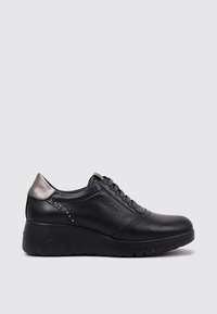 Baskets en cuir noir avec une semelle en caoutchouc texturé, des accents métalliques argentés sur le talon et des clous décoratifs sur le côté. Conception à lacets.