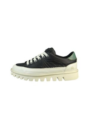 Zapatilla en blanco y negro con suela texturada prominente, parte superior acolchada en negro, cordones blancos y un acento trasero verde.