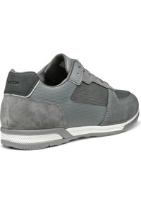 Scarpa atletica grigia con una combinazione di tessuti lisci e testurizzati, dettagli in suede e una suola in gomma bianca con un motivo di grip testurizzato.