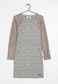 Robe grise avec des manches longues en dentelle. Présente un motif floral en rose et vert. Comprend une poche kangourou et une étiquette de marque à l'ourlet.