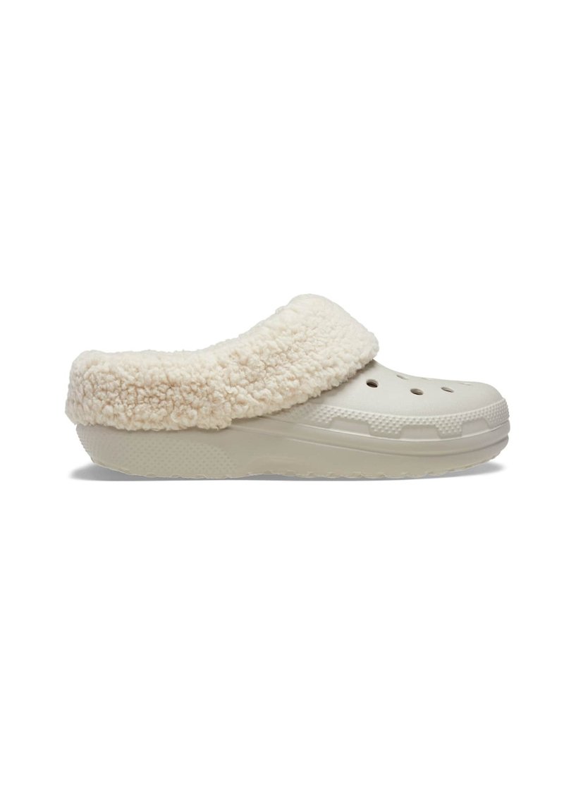 Lichtbeige klompen met een zachte, pluizige crèmekleurige kraag en ventilatiegaten op de bovenkant. Geprofileerde zool voor grip en stabiliteit.