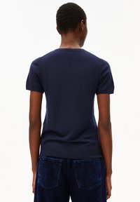 Navyblauw kortemmouw trui met een ronde hals, voorzien van een soepele textuur en een aansluitend ontwerp, gecombineerd met donkerblauwe flanelle broek.