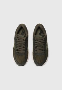 Olive green athletic shoes made of mesh and suede, featuring laces, reinforced toe, and a white rubber sole. Designed for comfort and stability.