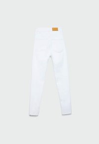 Jean en denim blanc avec une coupe droite, cinq poches et un patch en cuir brun avec marque à la taille. Ourlet brut aux poignets.