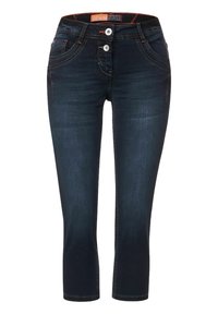 Tmavě modré džíny capri s přiléhavým střihem, které mají dvě přední kapsy, dvě zadní kapsy a kontrastní oranžové švy.