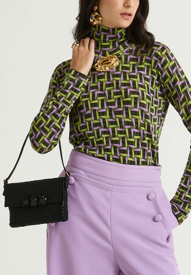 Borsa a tracolla nera con perline, con patta, superficie testurizzata e tre accenti lucidi, abbinata a un dolcevita con motivo verde e viola e pantaloni lilla.