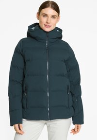 Giacca puffer di un verde scuro con zip frontale, cappuccio e tasche laterali. Presenta sezioni trapuntate e una superficie liscia.