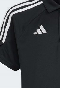 Zwarte poloshirt van ademend materiaal, met witte drie-strepen accenten op de schouders en een geborduurd driehoekig logo.