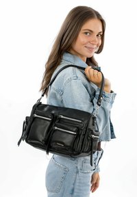 Black leather handbag with three zippered pockets, structured design, adjustable strap, and smooth texture. Worn over the shoulder.