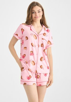 Ensemble de pyjama rose à manches courtes avec un imprimé de hérisson, comprenant une chemise à boutons et un short assorti, fabriqué en tissu doux.