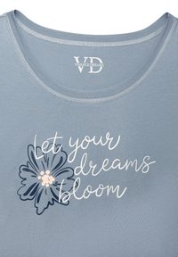 Light blue t-shirt with a rounded neckline, featuring the text "Let your dreams bloom" in white, and a floral design in darker blue with pink accents.