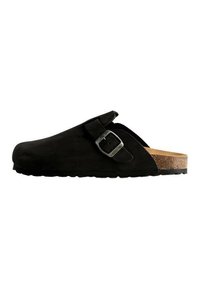 Black suede clog with a rounded toe, adjustable metal buckle detail, and a cork footbed, featuring a textured rubber sole.