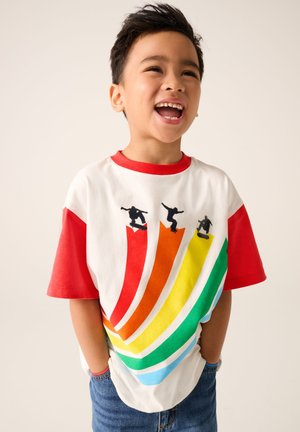 T-shirts met korte mouwen in een witte kleur, rode mouwen en een kleurrijk verloopdesign met skateboard-silhouetten. Denimhorts zichtbaar.