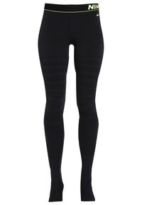 Černé sportovní legíny s přiléhavým střihem, které mají neonově žlutý pas a texturované pruhy podél nohavic pro lepší přilnutí a podporu.