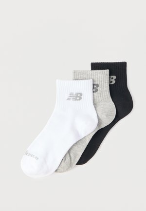Trois chaussettes courtes aux chevilles en blanc, gris et noir, chacune avec un bord-côtes et un petit logo "NB" près du haut.