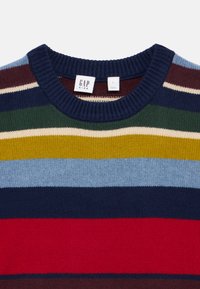 Gebreide pullovertrui met horizontale strepen in marineblauw, rood, groen, geel en blauw. Geribbelde kraag en manchetten. Etiket zegt "GAP KIDS."