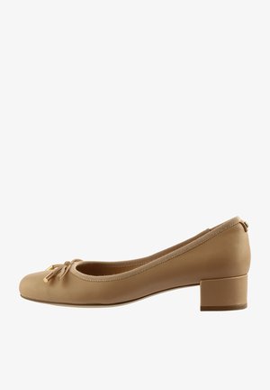 Beige leren balletschoenen met een ronde neus, kleine blokhak en decoratieve strikdetail. Zachte textuur en elastische afwerking langs de opening.
