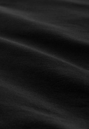 Musta kangas, jossa on sileä pinta ja hienovaraisia syvyyseroja, jotka luovat pehmeitä aaltoja ja varjoja pinnalle.