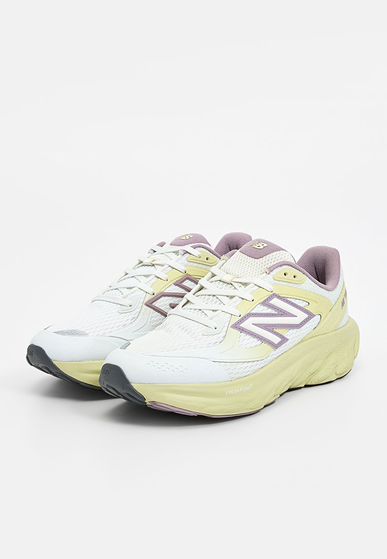 Zapatillas de correr ligeras en blanco con acentos en amarillo y lavanda. Parte superior de malla, suela acolchada y un marcado logotipo en el costado.