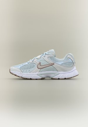 Hellblauer und weißer Nike-Laufschuh mit Mesh-Einsätzen, beigem Swoosh-Logo und dicker gepolsterter Sohle vor neutralem Hintergrund.