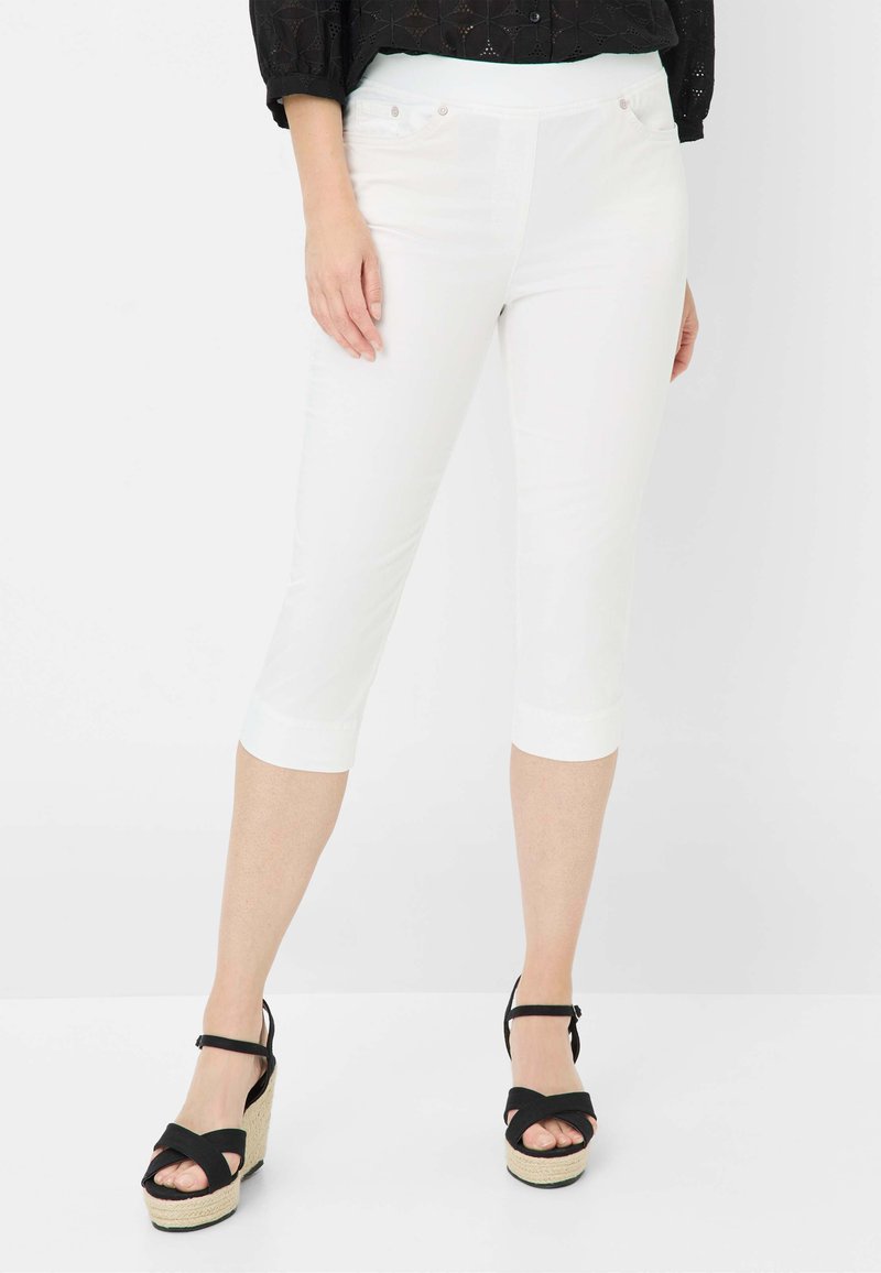Pantaloni capri bianchi con vestibilità slim, caratterizzati da una texture liscia, due tasche frontali e orlo rifinito. Abbinati a sandali con zeppa neri e fasce.