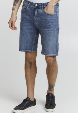 Jeansshorts i en ljusblå tvätt, med rak skärning och fransad nederkant. Har fem fickor, bältesöglor och en sliten textur.