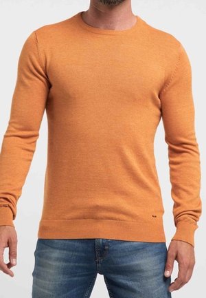 Orange crew neck-trøje lavet af blødt stof med ribbede manchetter og kant, kombineret med blå jeans. Forfra, fokus på tekstur og pasform.