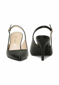 Črne usnjene slingback visoke pete s koničastim nosom in stileto peto. Imajo nastavljiv gleženjski trak in gladko teksturo na zgornjem delu.