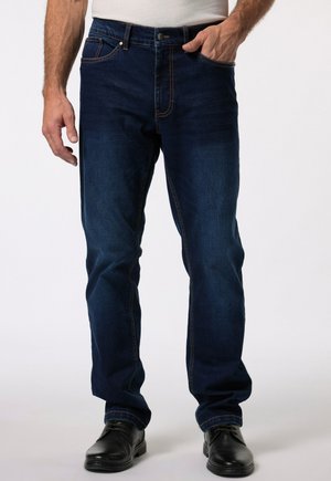 Jeans en denim bleu foncé avec une coupe droite, présentant des coutures contrastées, des poches frontales et une fermeture à bouton.