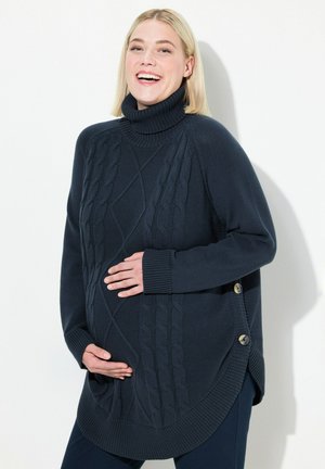 Pull à col roulé tricoté en marine foncé avec un design en maille torsadée, des accents de boutons sur le côté et une coupe décontractée, adapté pour le port pendant la grossesse.