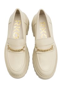 Cream-colored leather loafers with a textured finish, featuring a gold chain accent on the upper and a thick, contoured sole.