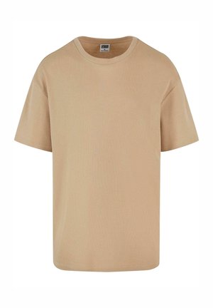 Camiseta de manga corta beige hecha de tejido de canalé, con cuello redondo y un corte relajado. Diseño simple y limpio.
