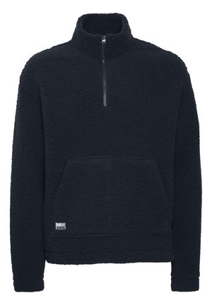 Black fleece pullover with a high collar, half zipper, textured exterior, and a front kangaroo pocket. Features a small logo patch.