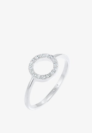 Srebrny pierścionek z okrągłym otwartym wzorem otoczony małymi, przezroczystymi kamieniami, polerowane wykończenie i oznaczony znakiem "925" dla srebra sterlingowego.