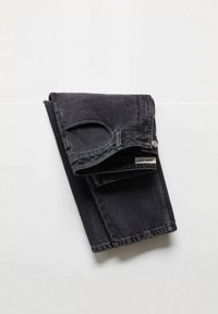 Jeans de mezclilla negra doblados cuidadosamente, con un ligero desgaste, diseño tradicional de cinco bolsillos y una etiqueta de marca visible en la cinturilla.