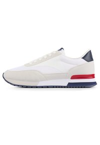 Weiße und beige Sneaker mit einem strukturierten Obermaterial, navyfarbenen Akzenten, rotem Fersenbereich und einer geriffelten Sohle. Sie verfügen über ein Schnürdesign.