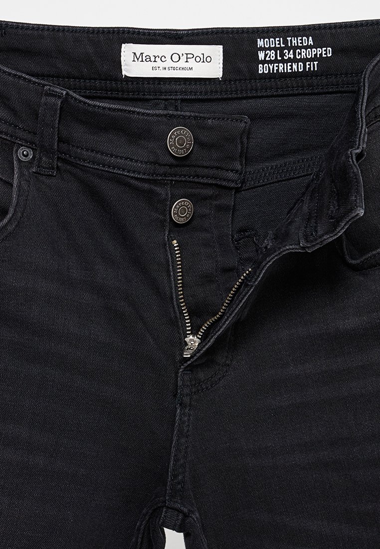 Czarne, krótkie dżinsy boyfriend w stylu z częściowo rozpiętym zamkiem, dwoma metalowymi guzikami oraz metką marki Marc O’Polo wszytą w pasie.