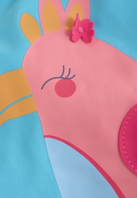 Ljust blått tyg med en rosa djurdesign med gula accenter, en rosa blomdetalj och svarta konturer för ansiktsdrag.