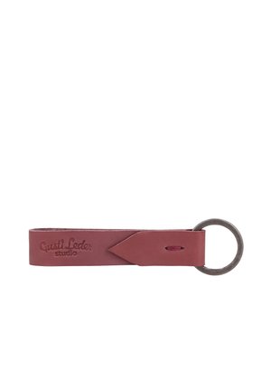 Short brown leather keychain loop with a metal ring on one end and "Gusti Leder studio" embossed on the leather.