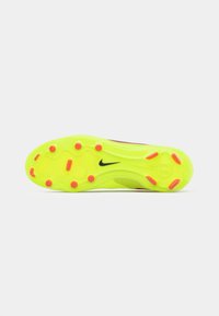 Suela de botas de fútbol de Nike en un vibrante amarillo neón con acentos en rosa. Presenta tacos moldeados para tracción y un diseño elegante y aerodinámico.