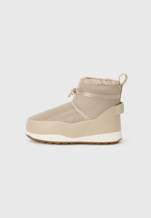 Beige waterproof boot with a textured mesh upper, padded collar, elastic drawstring, and rubber sole for traction. Reinforced back for support.