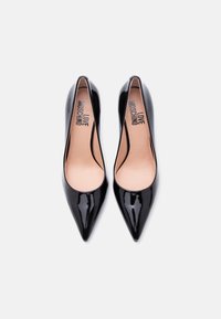 Μαύρα γόβες από λείο δέρμα με μυτερή μύτη, με λείο φινίρισμα, που διαθέτουν μπεζ πάτο με ανάγλυφο το γράμμα "LOVE MOSCHINO".