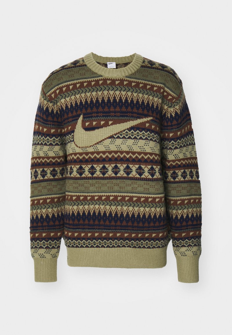 Pull en tricot vert, marron et marine. Présente des motifs géométriques et un grand logo beige de Nike. Encolure et poignets côtelés.
