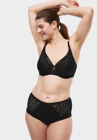 Zwarte kanten beha met een doorschijnend paneel en bijpassende hooggesneden slip met decoratieve patronen. Gladde textuur, naadloos ontwerp, zachte stof.