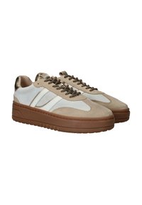 Beige suède sneakers met witte accenten, ronde neus, dikke bruine zool en donkerbruine veters. Maatstaf metalen hiel detail voegt contrast toe.