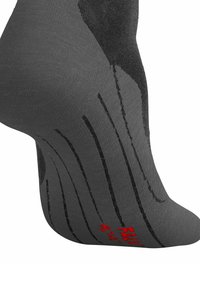 Graue Socke mit verstärktem Fersen- und Zehenbereich, ausgestattet mit schwarzen strukturierten Streifen und rotem Branding an der Sohle. Weiches Material mit glatter Oberfläche.